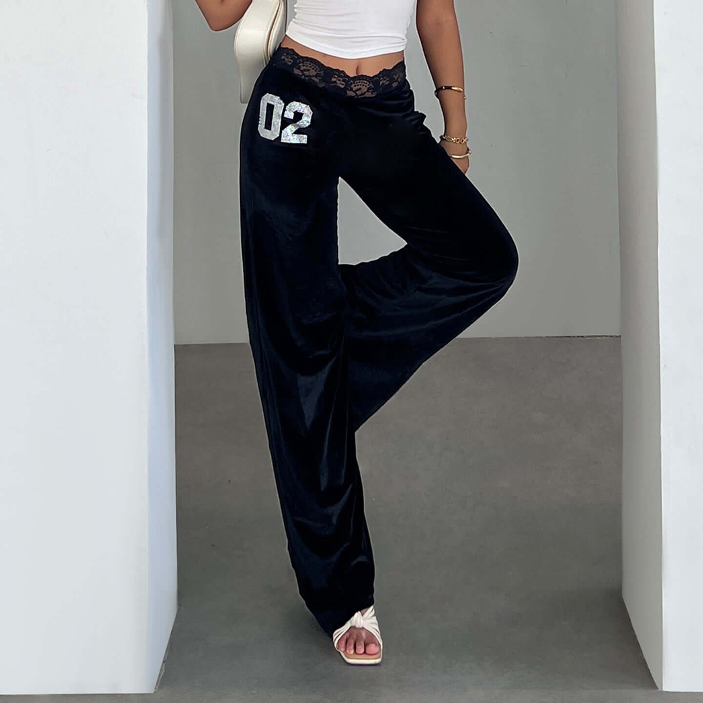 Pantalones negros de terciopelo con encaje y detalles brillantes